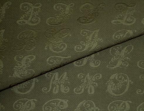 Closeup folded image of Script Upholstery and home decor fabric color Flint thick and soft double cloth Script Matelasse' Design with raised letters